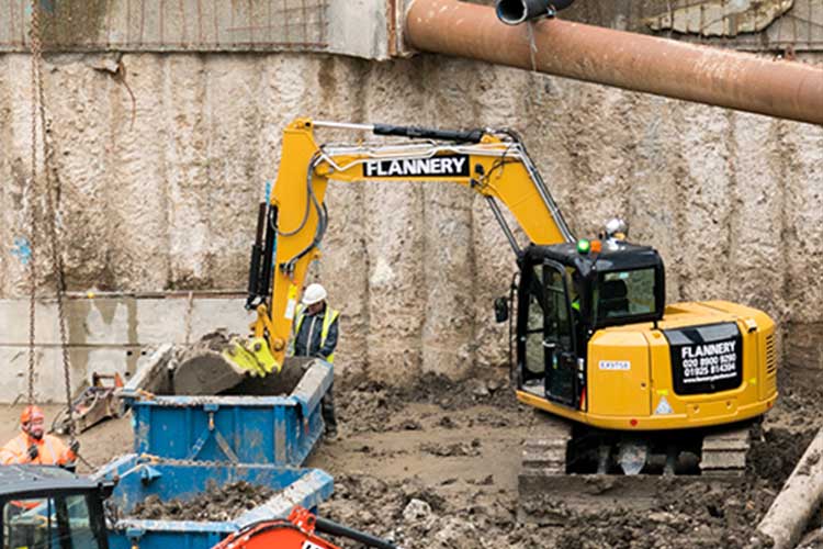 bulkx skip being loaded by an excavator