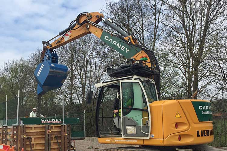 excavator pouring bucket attachment in use on site