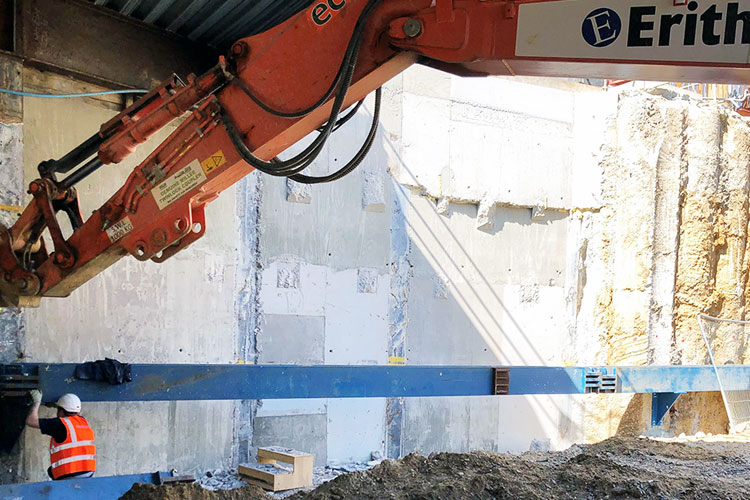 Site operative securing waling beam to wall at Paddington Cube site