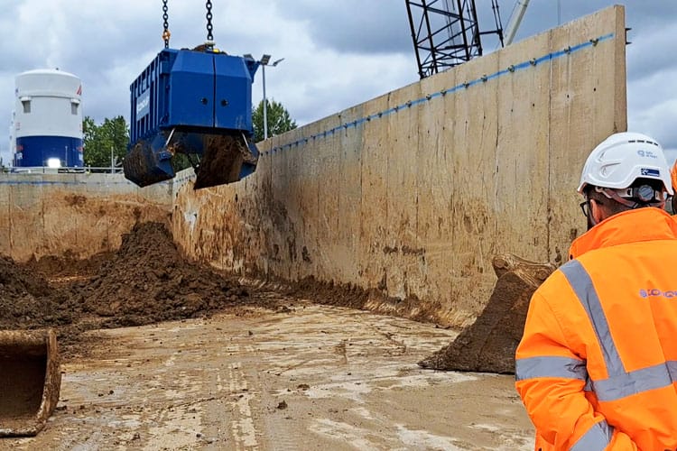 A large blue skip with Conquip on the side disposing of large quantities of soil.