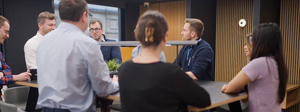 A group of people around a table talking