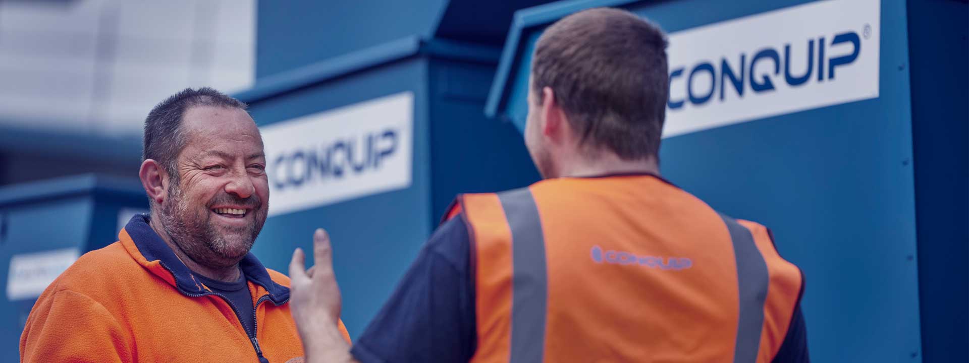 men talking next to hired equipment