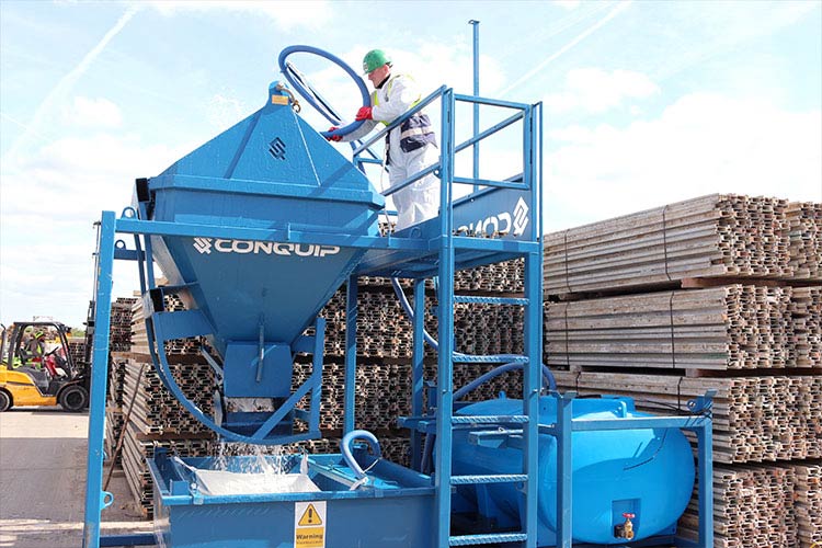 Man washing concrete skip with a concrete washout system