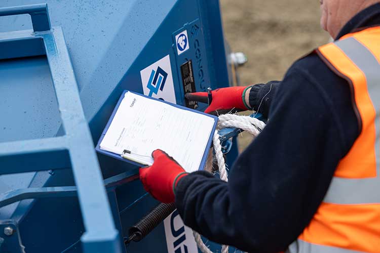 Man doing a safety check on concrete skip