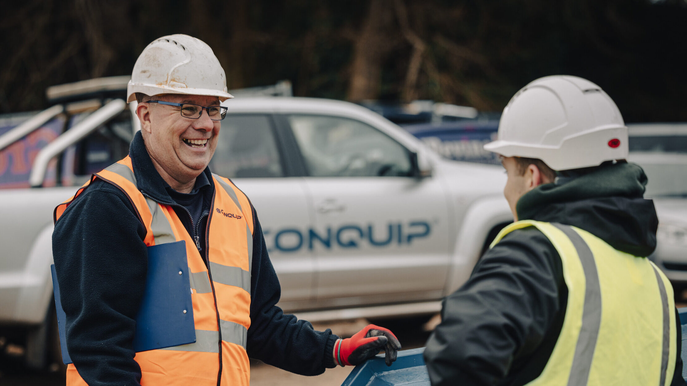 A man on a highvis training someone