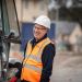 A man in a High-Vis jacket standing by a telehandler
