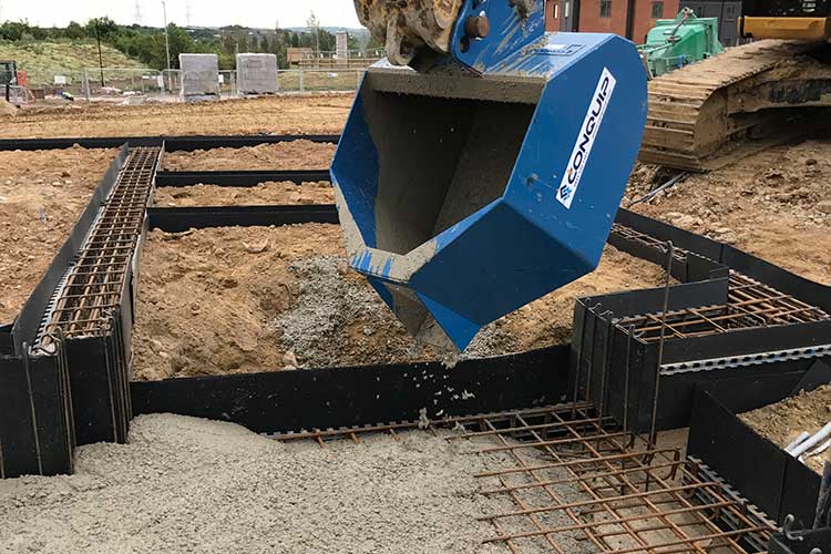 excavator pouring bucket used to pour concrete on a building site