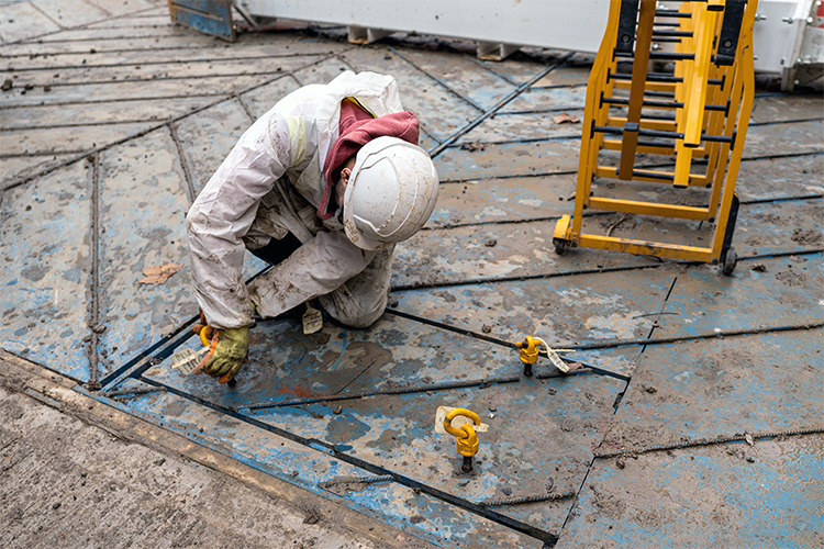 An engineer installs an access hatch into an excavator platform
